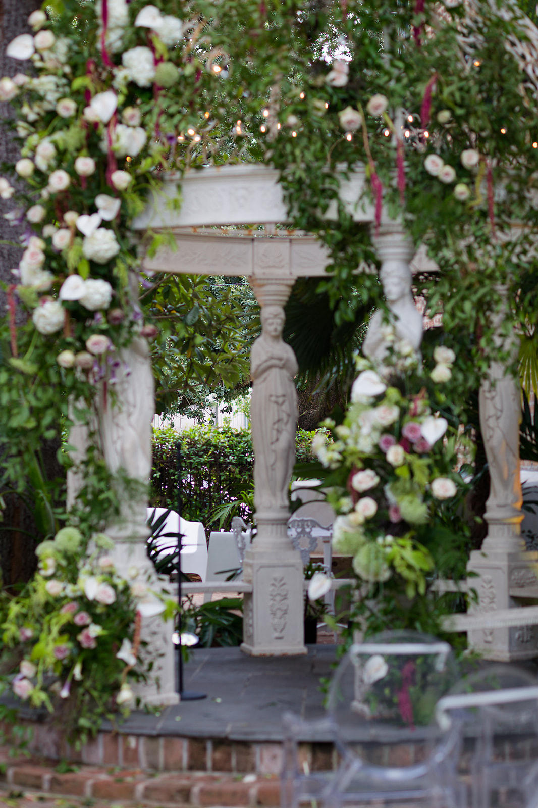 Garden gazebo ceremony draped in white roses, anthurium, and amaranthus