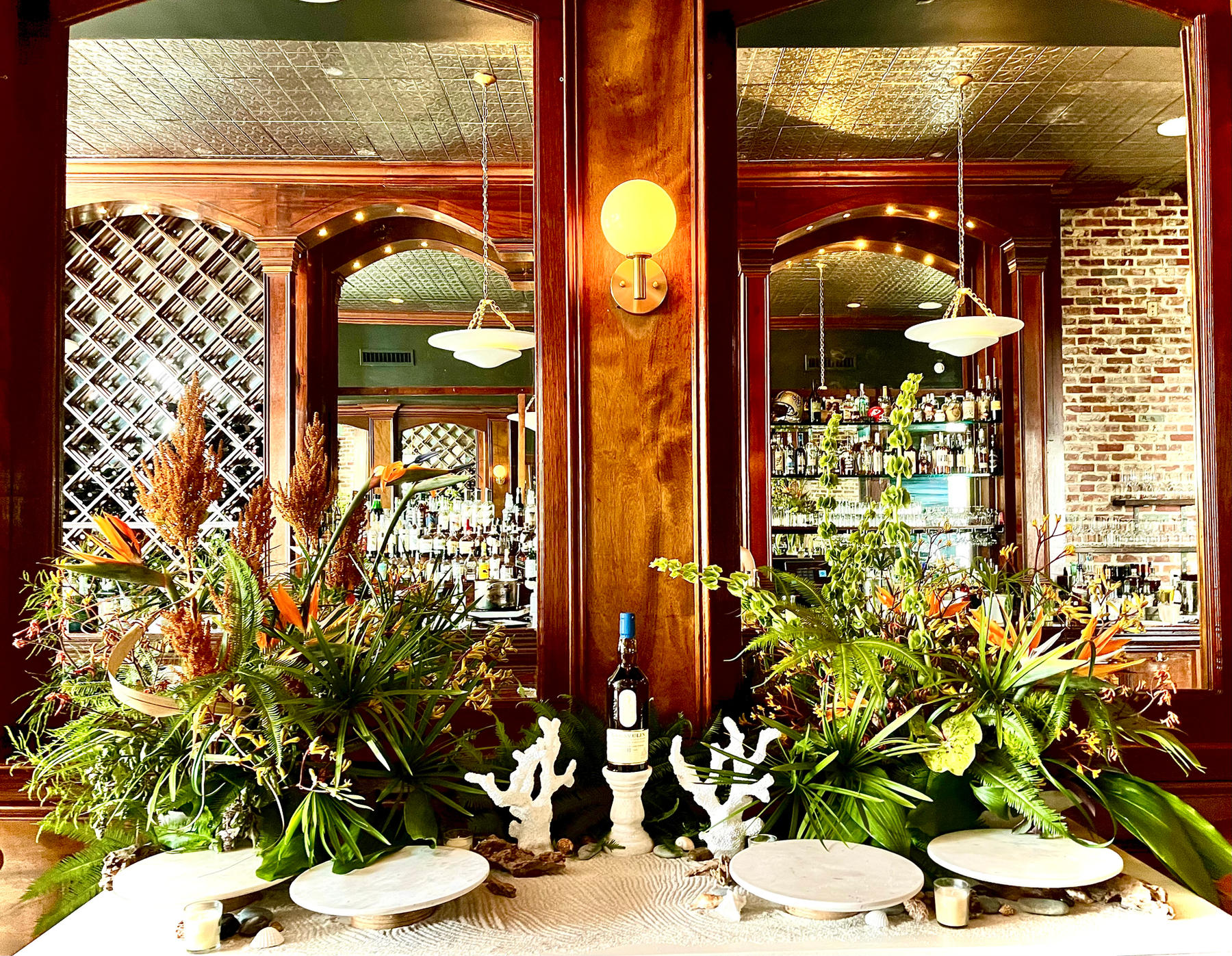 Tropical arrangement of birds of paradise and palms on a bar